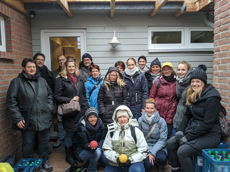 Gruppenfoto des Praxisteams in Winterjacken unter einem Vordach